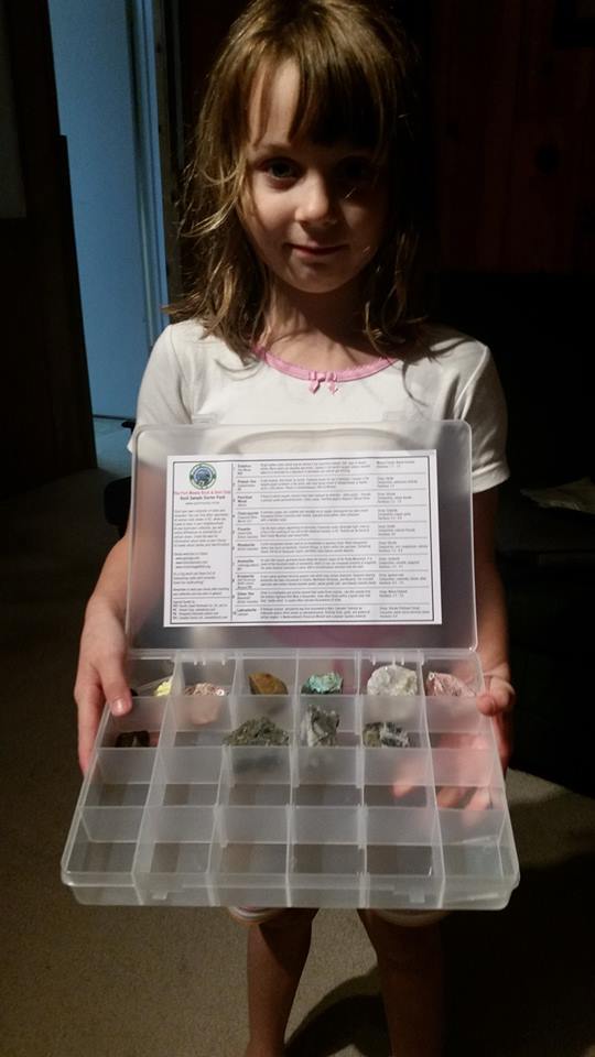 Young participant holding one of the 150 Rocks Canadian specimen boxes