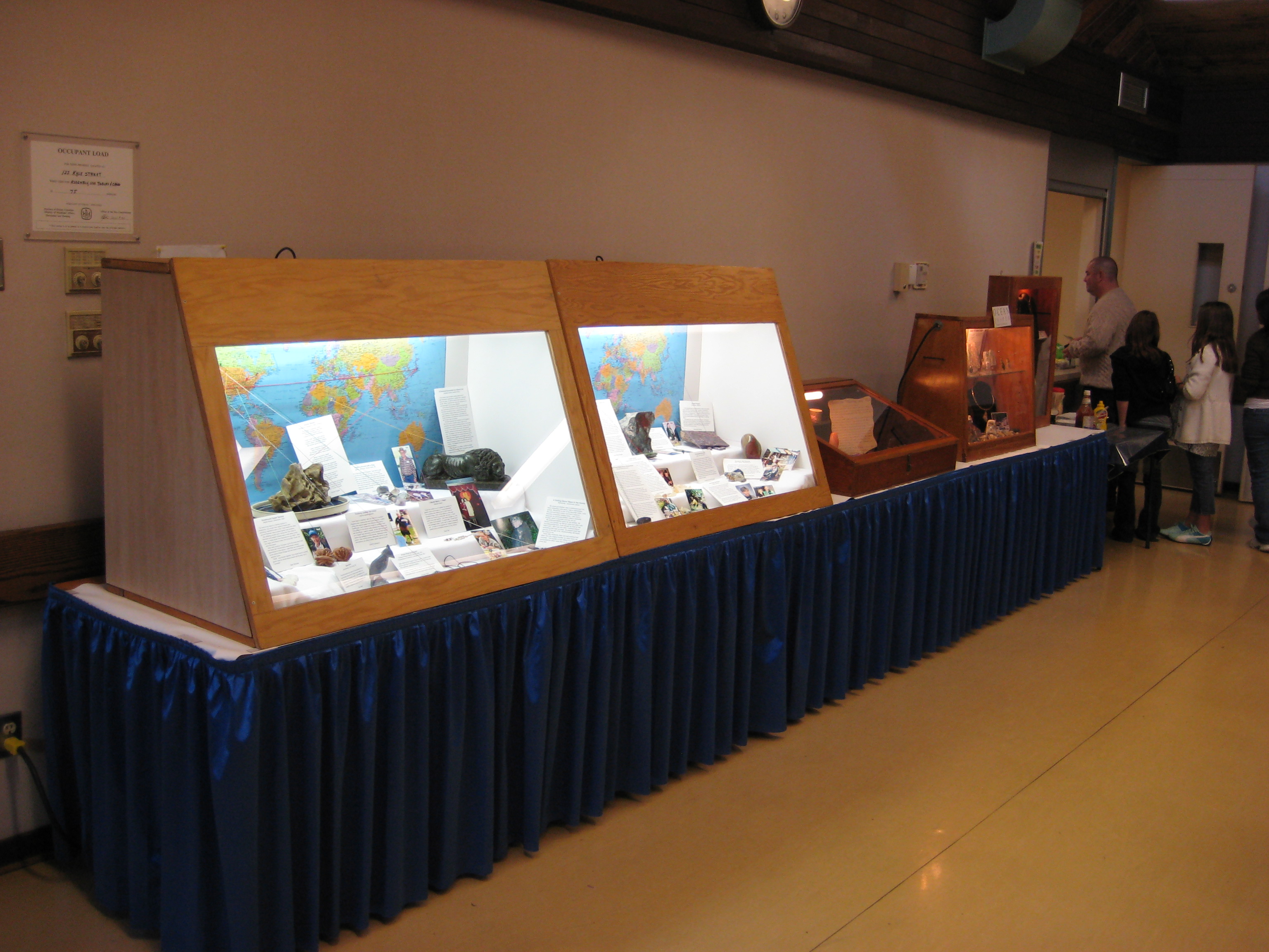 The central Rock My World exhibit with member specimens, written stories, world maps and lines connecting each stone to its place of origin.